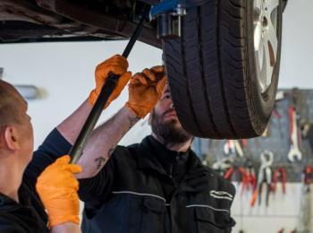 Mitarbeiter mit Auto auf Hebebühne